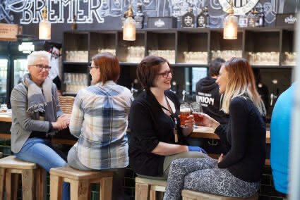 Menschen sitzen an einer Theke in der Union Brauerei in Bremen