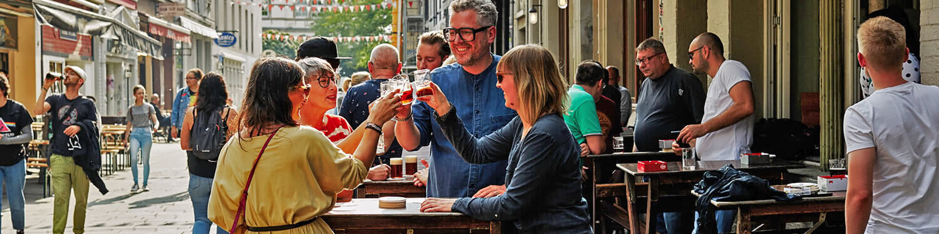 Gruppe stößt mit Altbier in der Düsseldorfer Altstadt an