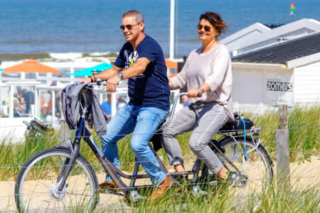 Ein Pärchen fährt mit einem Tandem durch Egmond aan Zee