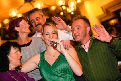 Fröhliche Gruppe beim Karaoke singen