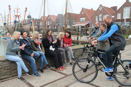 Gruppe macht Pause von einer Fahrradtour an einem kleinen Hafen in Neuharlingersiel