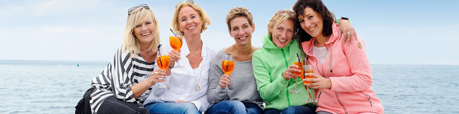 Frauengruppe trinkt gemeinsam Aperol Spritz am Strand von Norderney