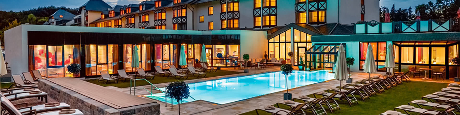 Außenansicht mit Pool vom Land & Golf Hotel Stromberg bei Dämmerung