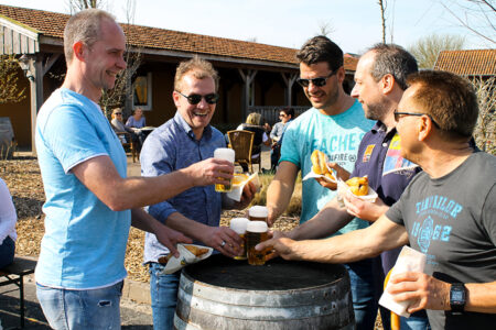 Männergruppe trinkt gemeinsam Bier und isst Wurst im Brötchen im Wangerland